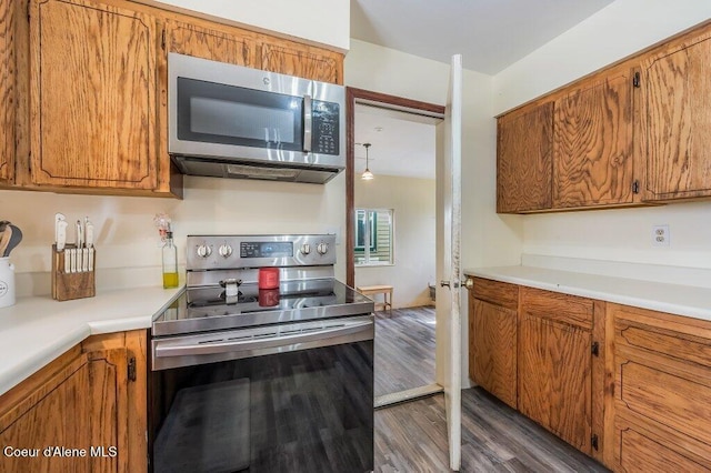 820 Plum Ln, Saint Maries, ID 83861 - kitchen featuring light countertops, brown cabinetry, stainless steel appliances, and dark wood-style flooring