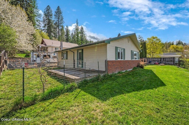 820 Plum Ln, Saint Maries, ID 83861 - rear view of house featuring a lawn, a fenced backyard, and brick siding