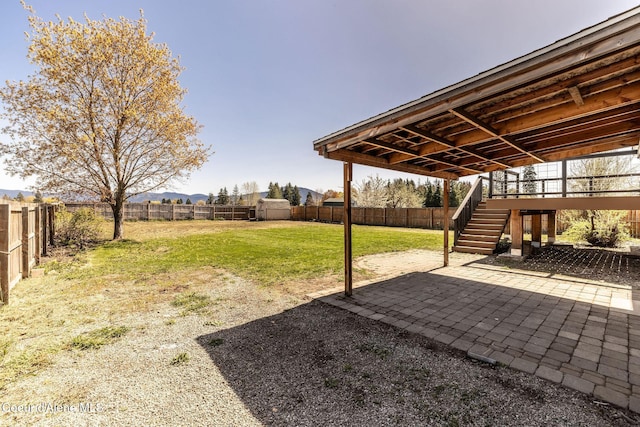 view of yard with stairway, a patio, and a fenced backyard