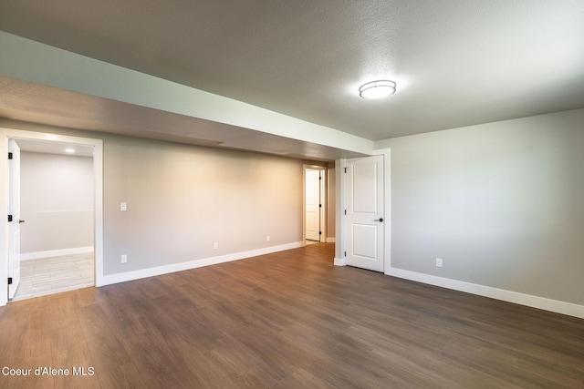 finished below grade area with baseboards and dark wood finished floors