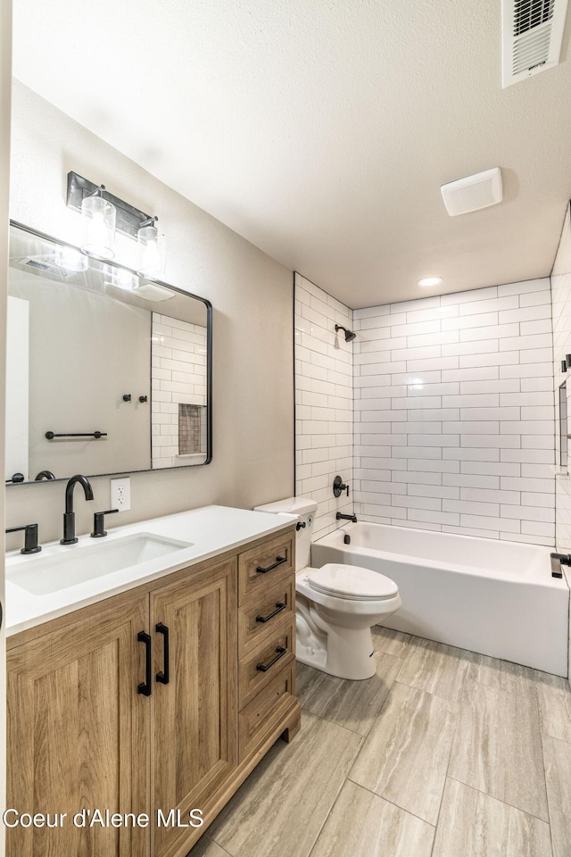 bathroom with vanity, toilet, visible vents, and bathtub / shower combination