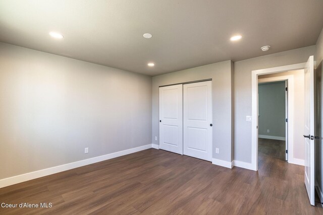 unfurnished bedroom featuring recessed lighting, baseboards, and dark wood-type flooring