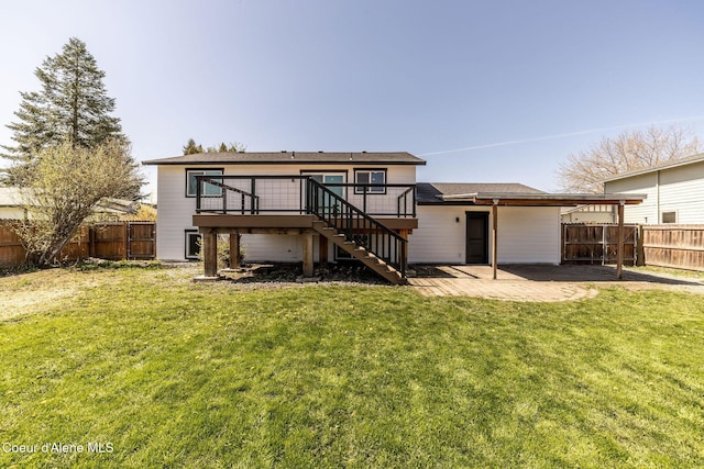 back of property featuring a lawn, a wooden deck, stairway, a fenced backyard, and a patio