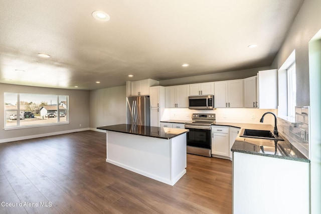 kitchen featuring backsplash, a center island, a sink, stainless steel appliances, and recessed lighting