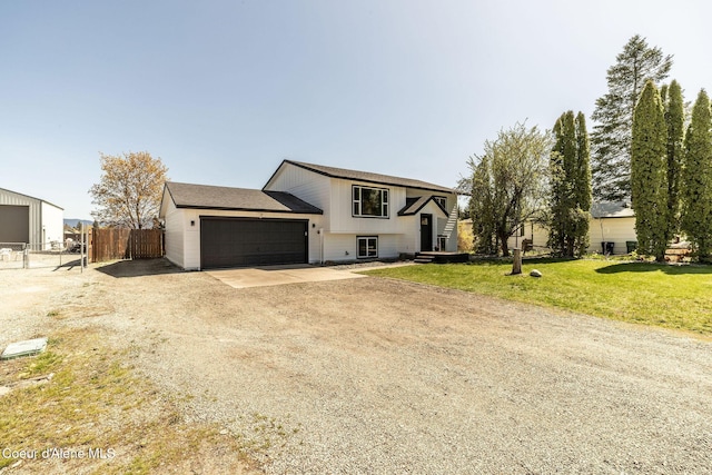 view of front of house featuring fence, a front lawn, driveway, and a garage