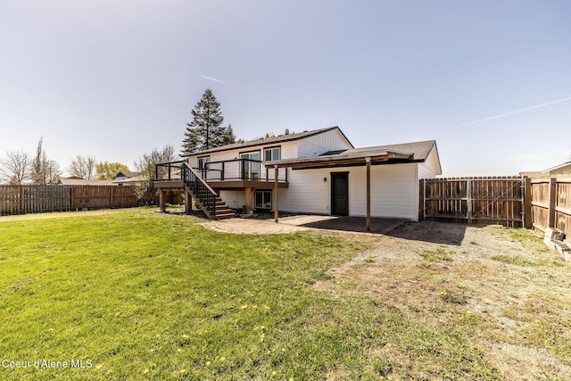 back of property with a lawn, a deck, a patio area, a fenced backyard, and stairs