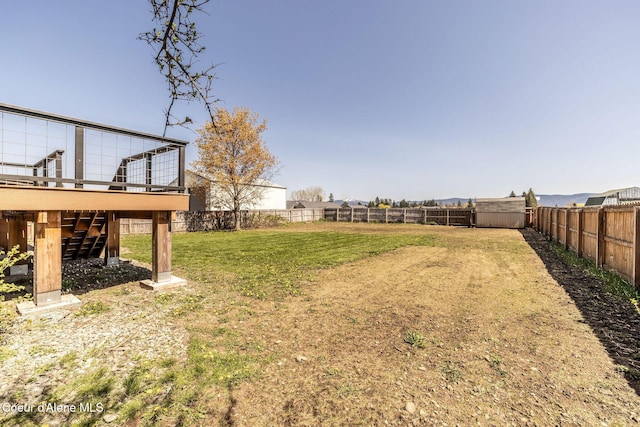 view of yard featuring stairs, a fenced backyard, and a deck