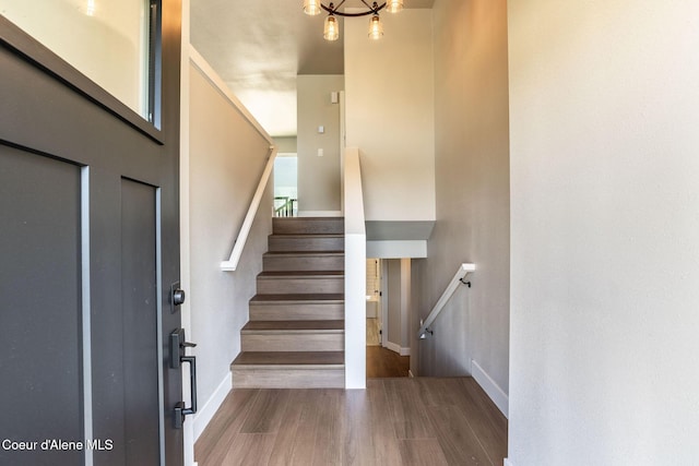 staircase featuring baseboards and wood finished floors
