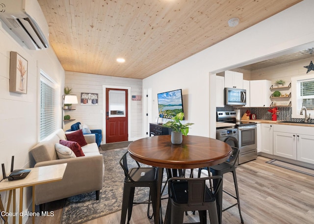 interior space featuring an AC wall unit, light wood finished floors, wooden walls, and wooden ceiling