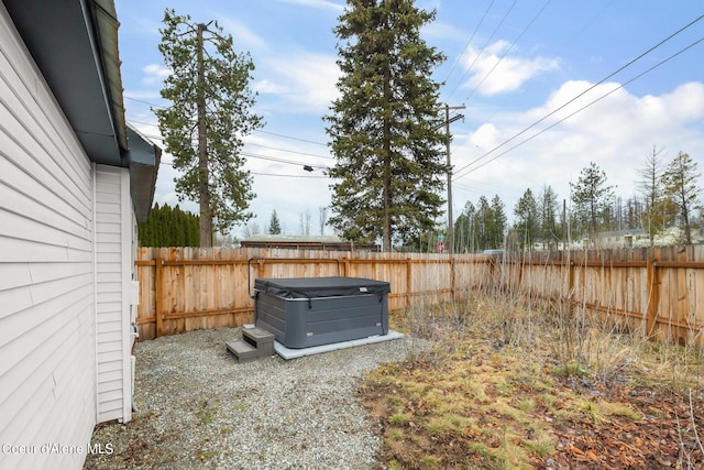 view of yard with a fenced backyard and a hot tub