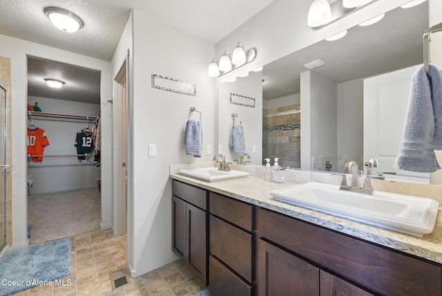 1622 N Minam Loop, Post Falls, ID 83854 - bathroom with a stall shower, a walk in closet, double vanity, stone finish floors, and baseboards
