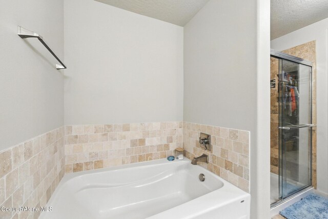 1622 N Minam Loop, Post Falls, ID 83854 - bathroom featuring a shower stall, a garden tub, and a textured ceiling