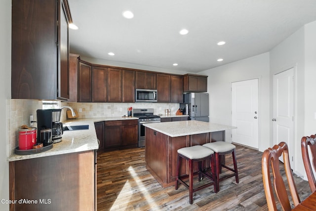 1622 N Minam Loop, Post Falls, ID 83854 - kitchen featuring appliances with stainless steel finishes, a sink, a kitchen island, dark wood-type flooring, and recessed lighting