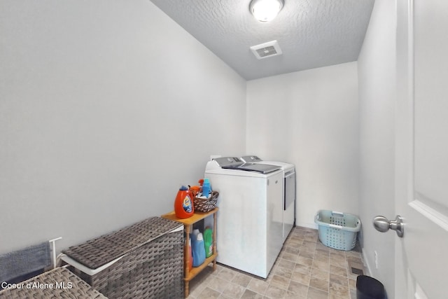 1622 N Minam Loop, Post Falls, ID 83854 - washroom featuring separate washer and dryer, a textured ceiling, and stone finish flooring