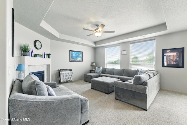 1622 N Minam Loop, Post Falls, ID 83854 - carpeted living room featuring a raised ceiling, a textured ceiling, a ceiling fan, and a fireplace