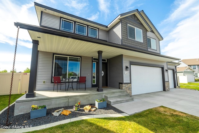 1622 N Minam Loop, Post Falls, ID 83854 - view of front facade with covered porch, fence, a garage, and concrete driveway