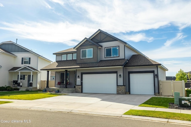 1622 N Minam Loop, Post Falls, ID 83854 - craftsman-style house featuring roof with shingles, driveway, a garage, and a porch