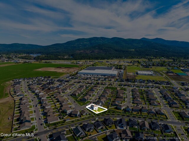 1622 N Minam Loop, Post Falls, ID 83854 - aerial overview of property's location with a mountain backdrop, property boundaries highlighted, and nearby suburban area