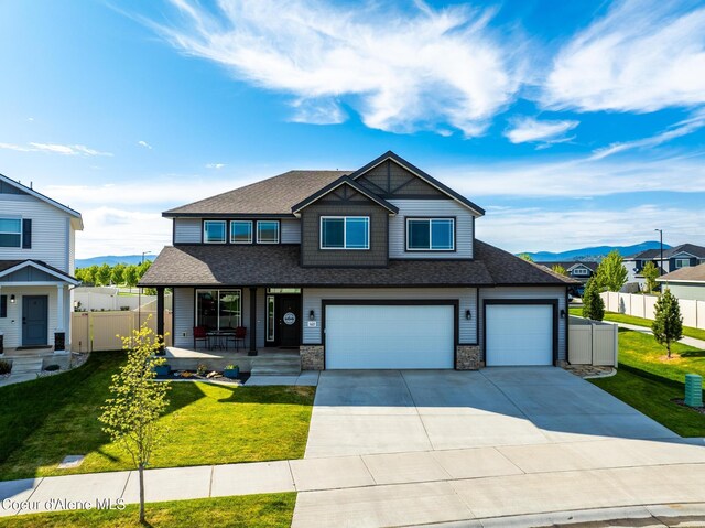 1622 N Minam Loop, Post Falls, ID 83854 - view of front facade with a porch, a shingled roof, driveway, a garage, and a mountain view
