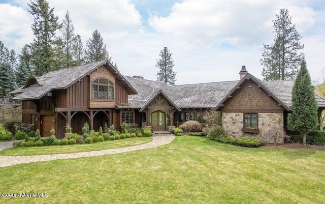 7566 E Gem Shores Rd, Hayden, ID 83835 - tudor home with a chimney, a front lawn, and stone siding