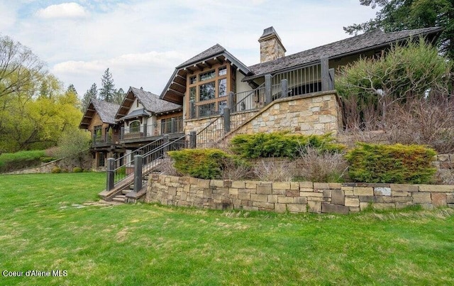 7566 E Gem Shores Rd, Hayden, ID 83835 - back of property featuring a chimney, a lawn, a wooden deck, stairs, and stone siding