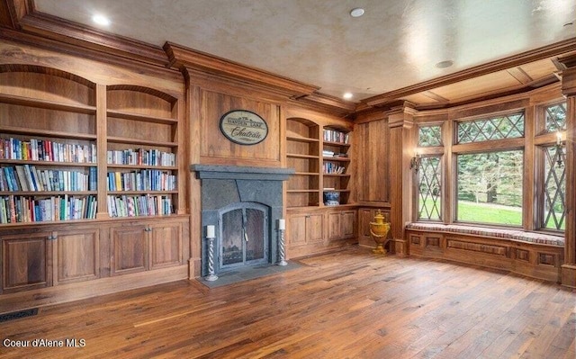 7566 E Gem Shores Rd, Hayden, ID 83835 - unfurnished living room with crown molding, wood walls, built in features, and a fireplace