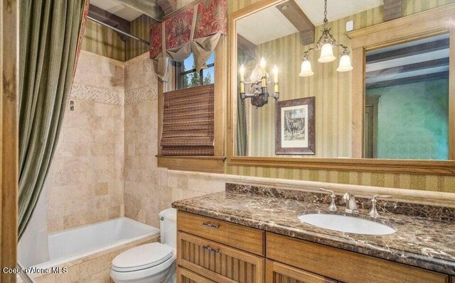 7566 E Gem Shores Rd, Hayden, ID 83835 - full bathroom featuring vanity, an inviting chandelier, toilet, tile walls, and tiled shower / bath combo