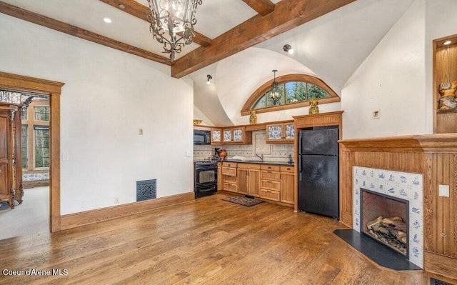 7566 E Gem Shores Rd, Hayden, ID 83835 - kitchen featuring vaulted ceiling with beams, a notable chandelier, wood finished floors, and black appliances