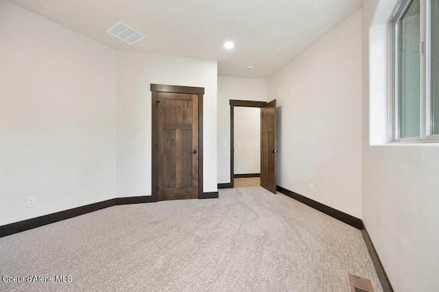 carpeted spare room with baseboards and visible vents
