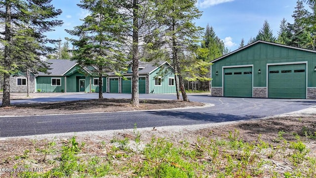view of front of house with a garage, board and batten siding, and stone siding