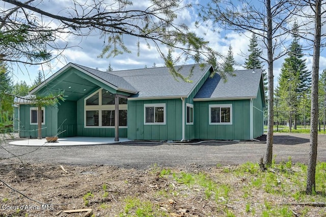 back of property with a shingled roof and board and batten siding
