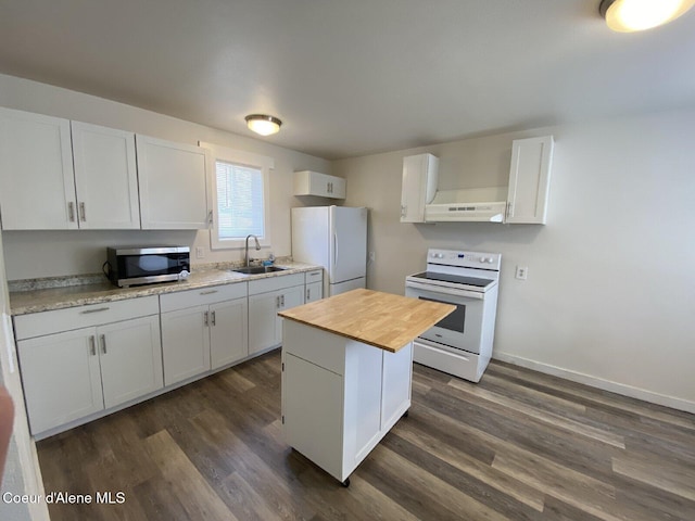 kitchen featuring dark wood-style flooring, a sink, wood counters, under cabinet range hood, and white appliances