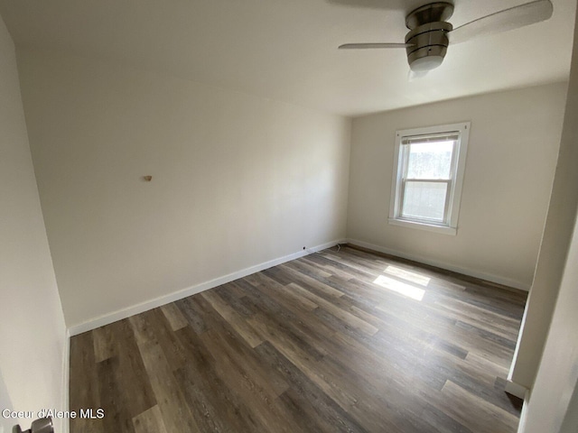 unfurnished room with baseboards, a ceiling fan, and dark wood-style flooring