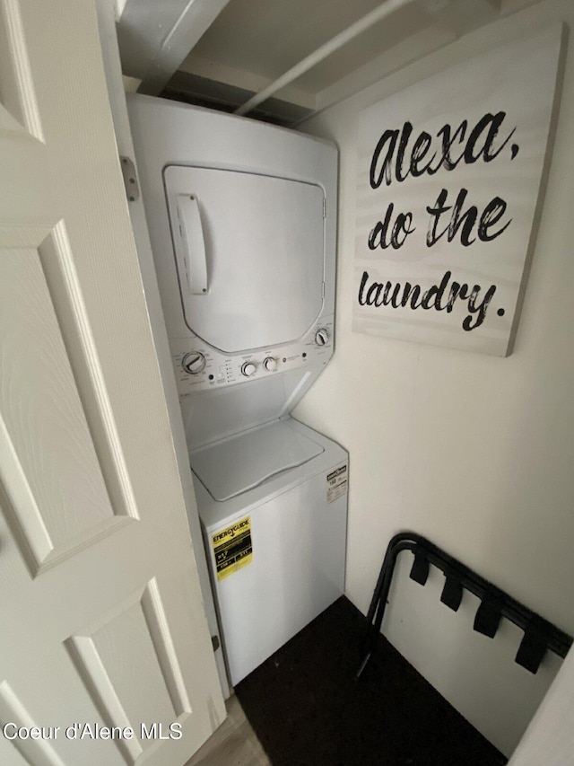 washroom with stacked washer and dryer and laundry area