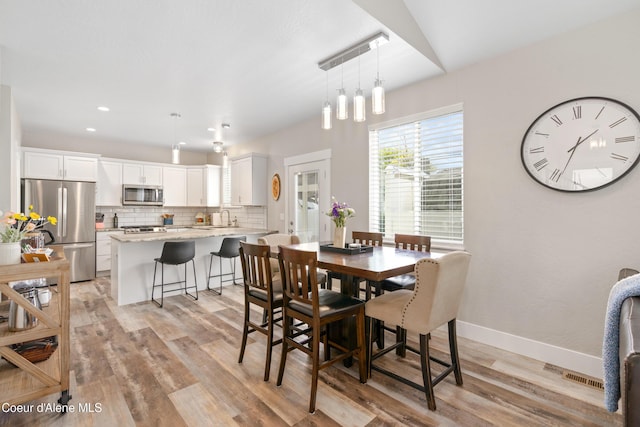 dining room featuring light wood-style floors, recessed lighting, baseboards, and visible vents