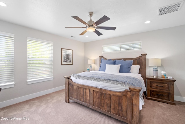 bedroom featuring visible vents, baseboards, and light carpet