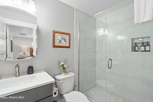 full bathroom with vanity, visible vents, toilet, and a shower stall
