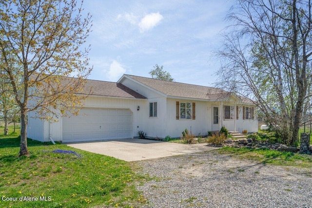 single story home featuring an attached garage, driveway, and a front yard