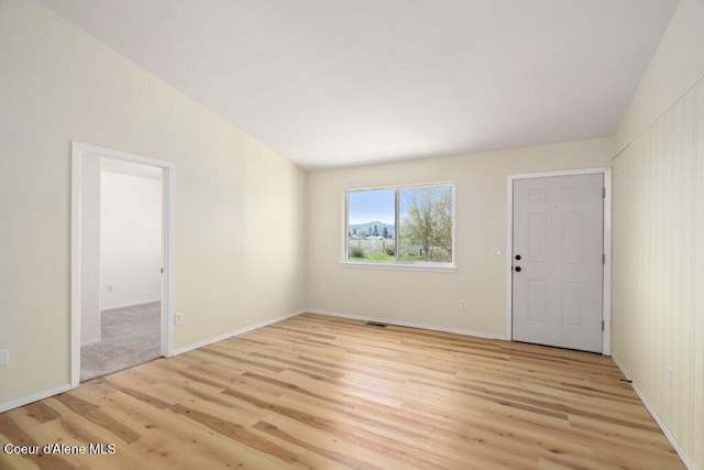 unfurnished room featuring light wood-style floors, baseboards, and visible vents