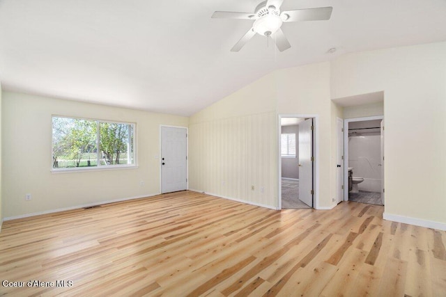 unfurnished living room with plenty of natural light, wood finished floors, and lofted ceiling