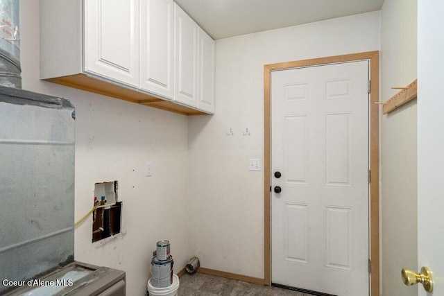 washroom with cabinet space and baseboards