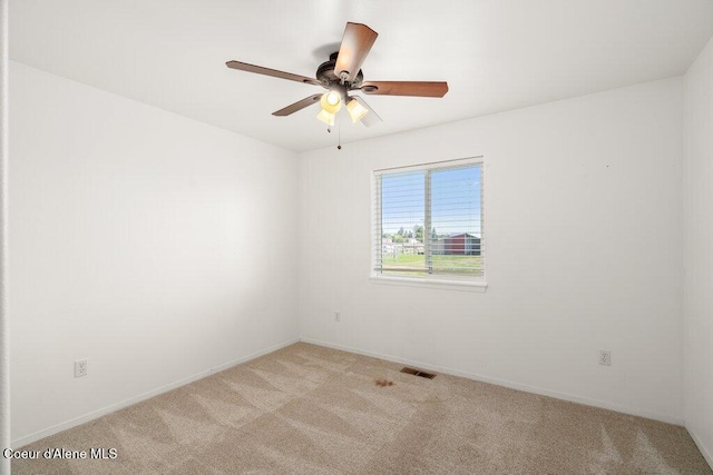 empty room with baseboards, a ceiling fan, light colored carpet, and visible vents
