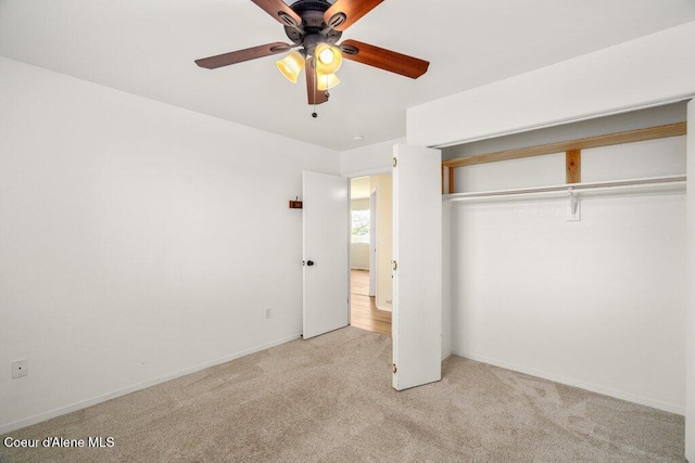unfurnished bedroom with a closet, carpet flooring, baseboards, and a ceiling fan
