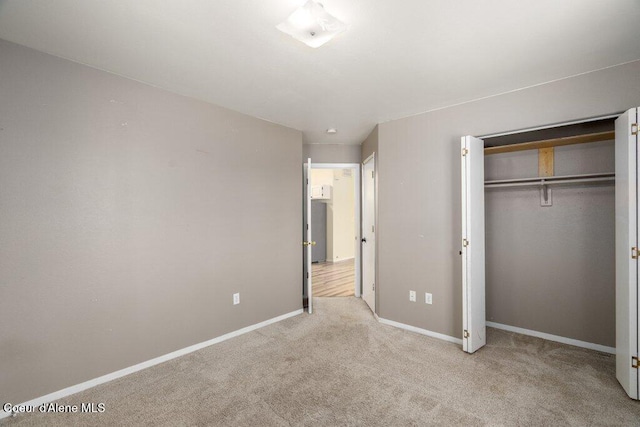 unfurnished bedroom with carpet flooring, baseboards, and a closet