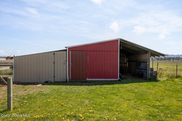 view of pole building featuring fence and a yard