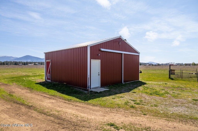 view of pole building with fence and a mountain view