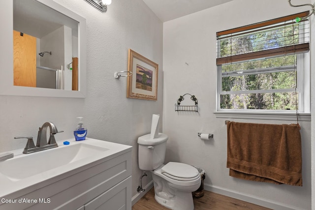 130 Stone Haven Dr, Blanchard, ID 83804 - full bathroom featuring vanity, toilet, baseboards, wood finished floors, and a shower with door