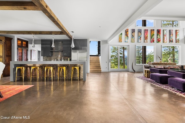 172 Elk Hills Rd, Sandpoint, ID 83864 - living room featuring finished concrete floors, stairs, a dry bar, and beam ceiling