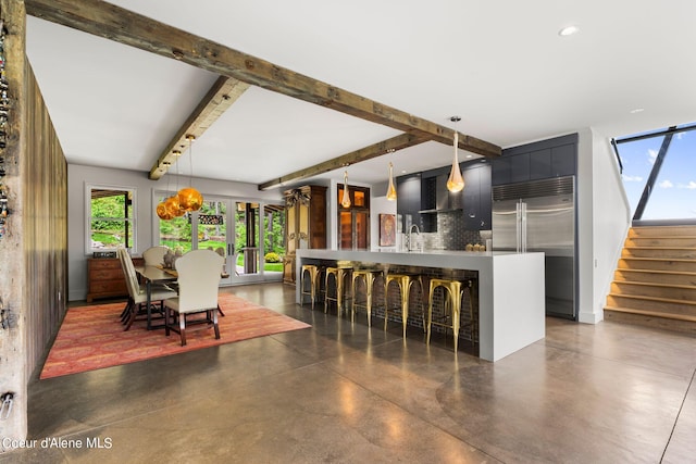 172 Elk Hills Rd, Sandpoint, ID 83864 - dining space featuring finished concrete flooring, beam ceiling, stairs, and bar