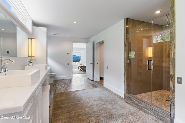 172 Elk Hills Rd, Sandpoint, ID 83864 - bathroom featuring double vanity, a shower stall, toilet, baseboards, and wood finished floors